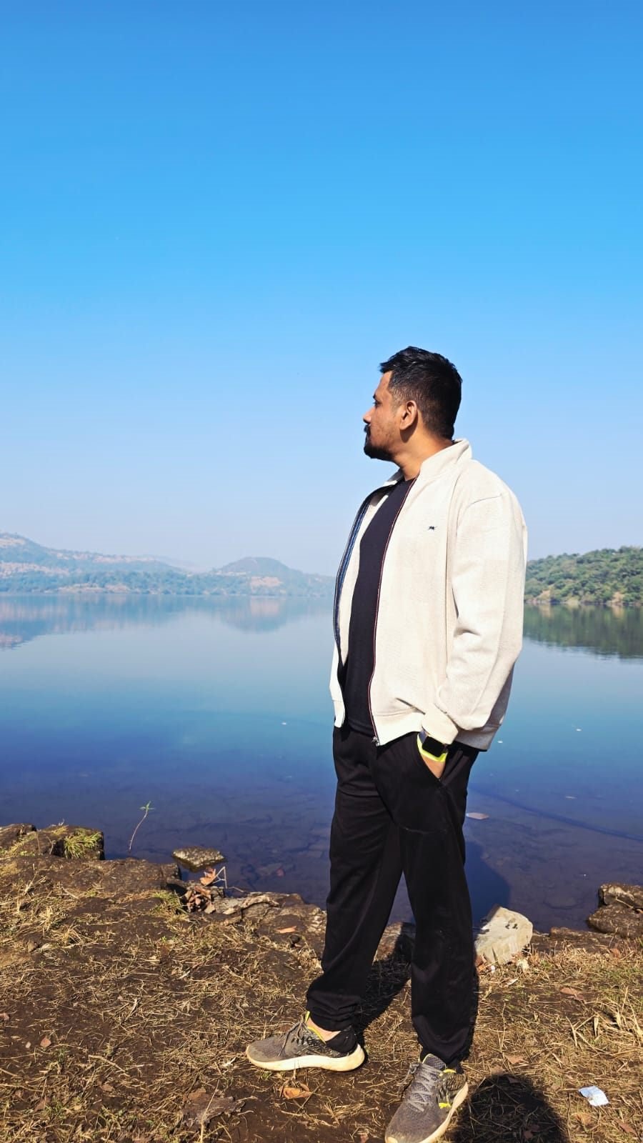 Deepraj by a calm lake, looking at the horizon