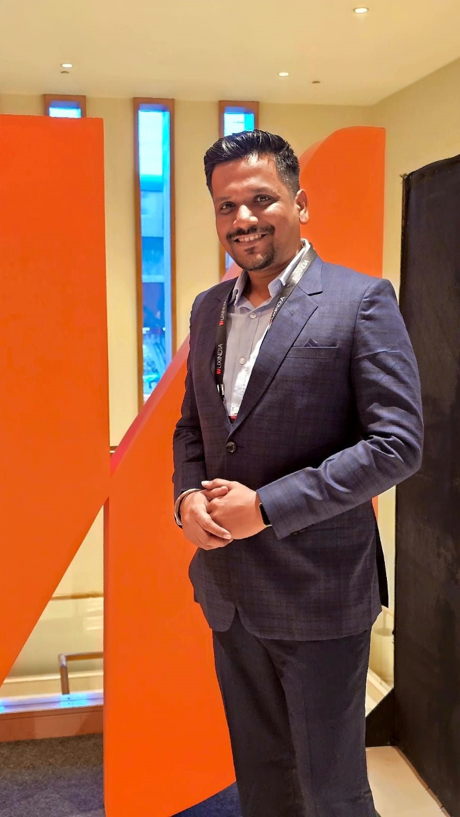 Deepraj in a navy suit at a UX conference